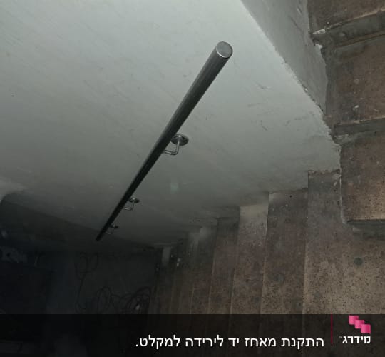 מעקה מתכת מותקן על קיר מדרגות בטון ישנות